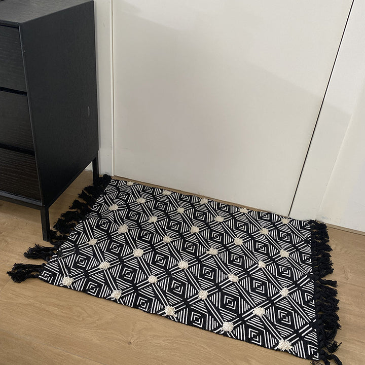Hand-tufted bathroom mat with fringes, decorative dot-and-dash pattern and non-slip backing Kalsten