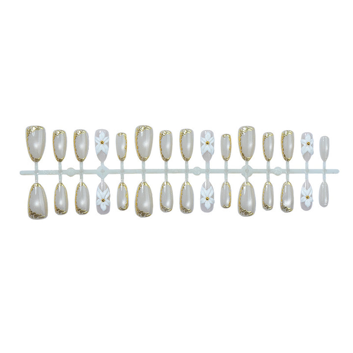 Acrylic nail set with elegant gold embellishments and floral accent Kalsten