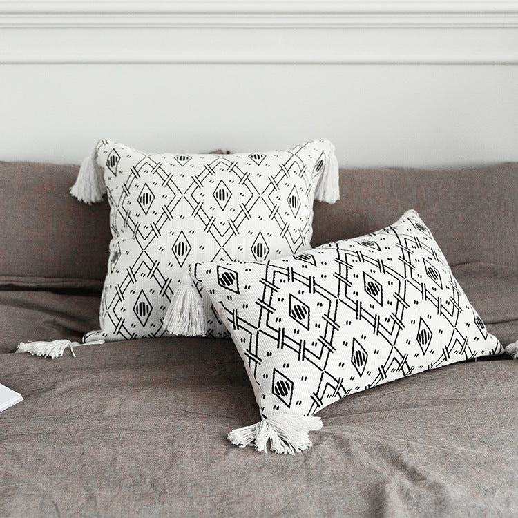 Square decorative cushion cover made of cotton blend with handwoven texture, geometric diamond print, and corner tassels