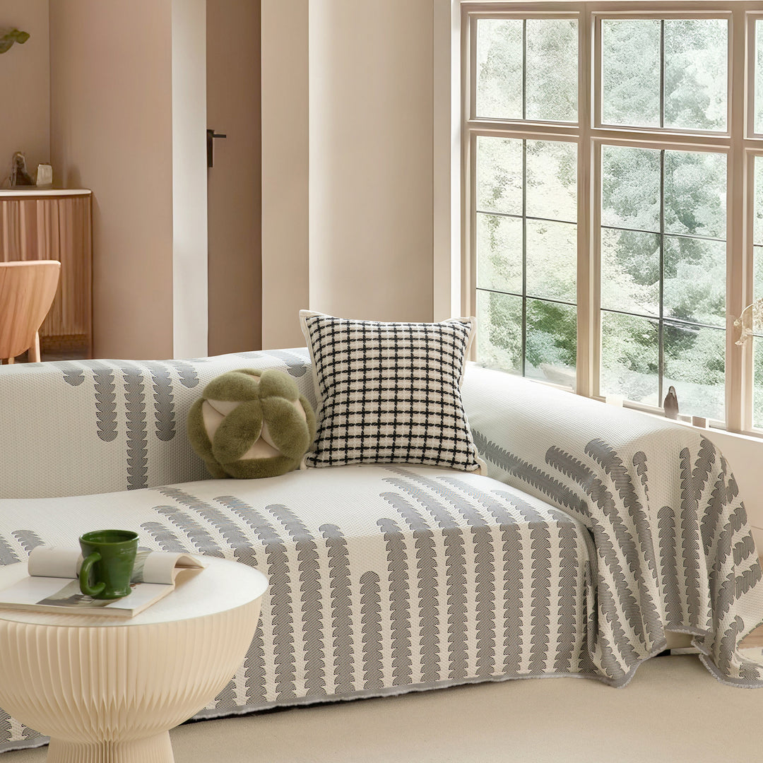 Geometric sofa cover made of cotton blend fabric with decorative fringe edge