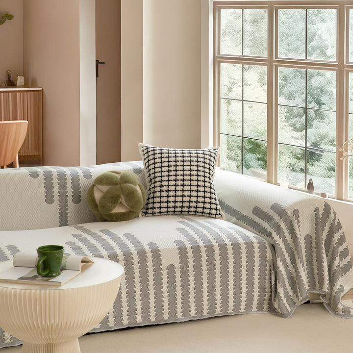 Geometric sofa cover made of cotton blend fabric with decorative fringe edge