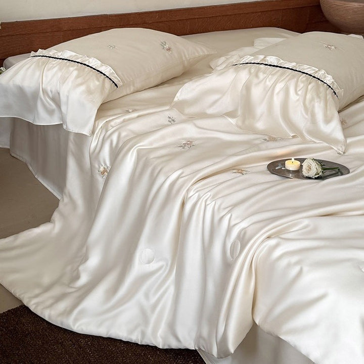 Exquisite satin bedding set with floral embroidery, gathered pillow shams, and contrasting piping
