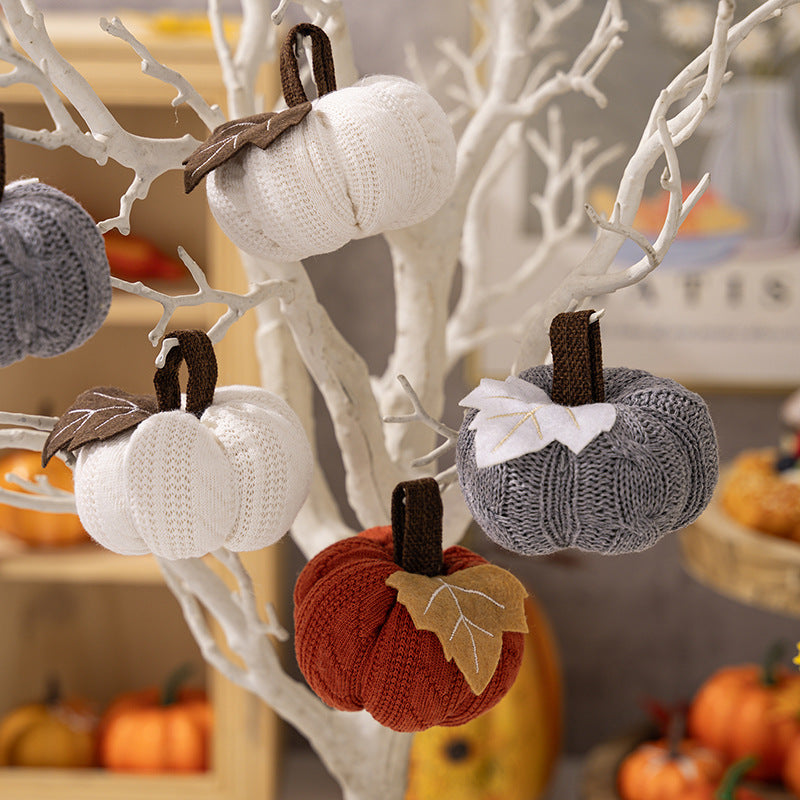 Knitted fabric pumpkin as autumn table decoration with felt leaf