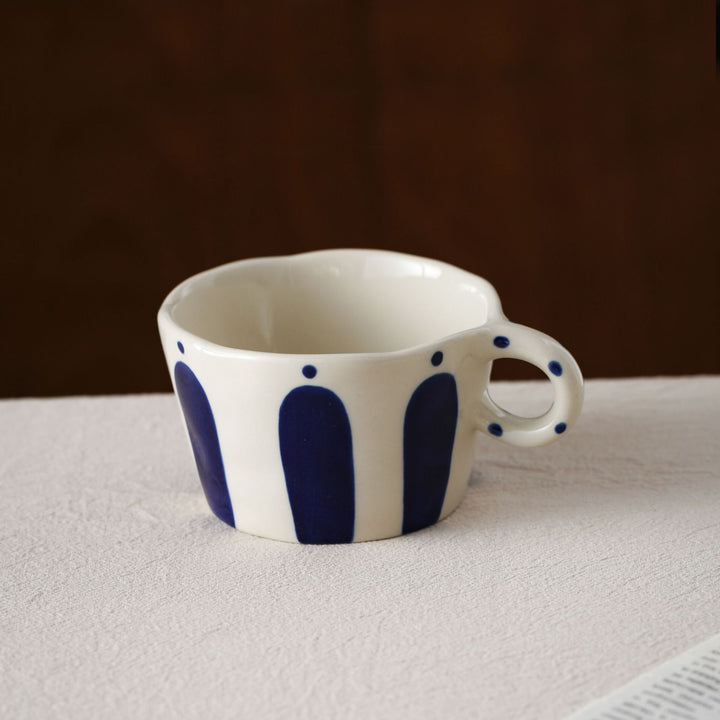 Handmade ceramic mug with ergonomic handle and wavy rim