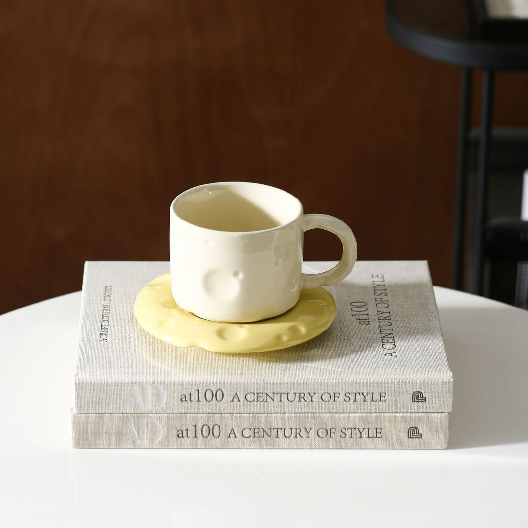 Ceramic coffee cup set with textured relief surface and wavy saucer