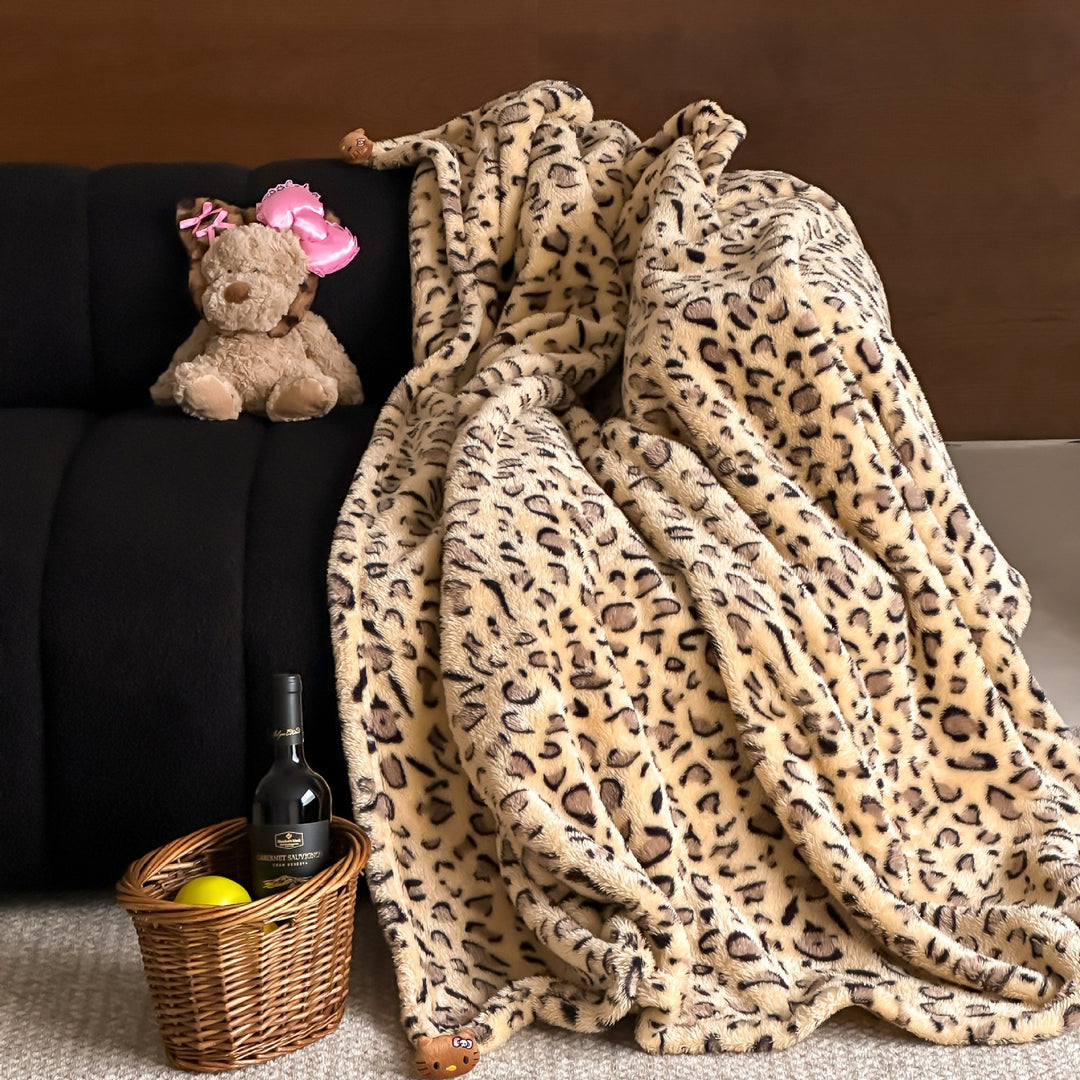 Cozy throw blanket made of microfleece with leopard print and plush pendants