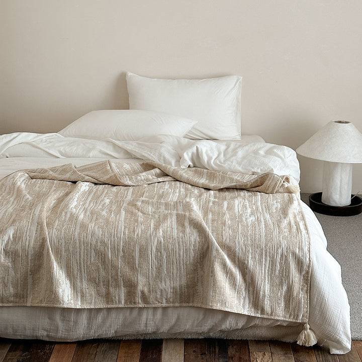 Woven blanket made of cotton blend with decorative tassels