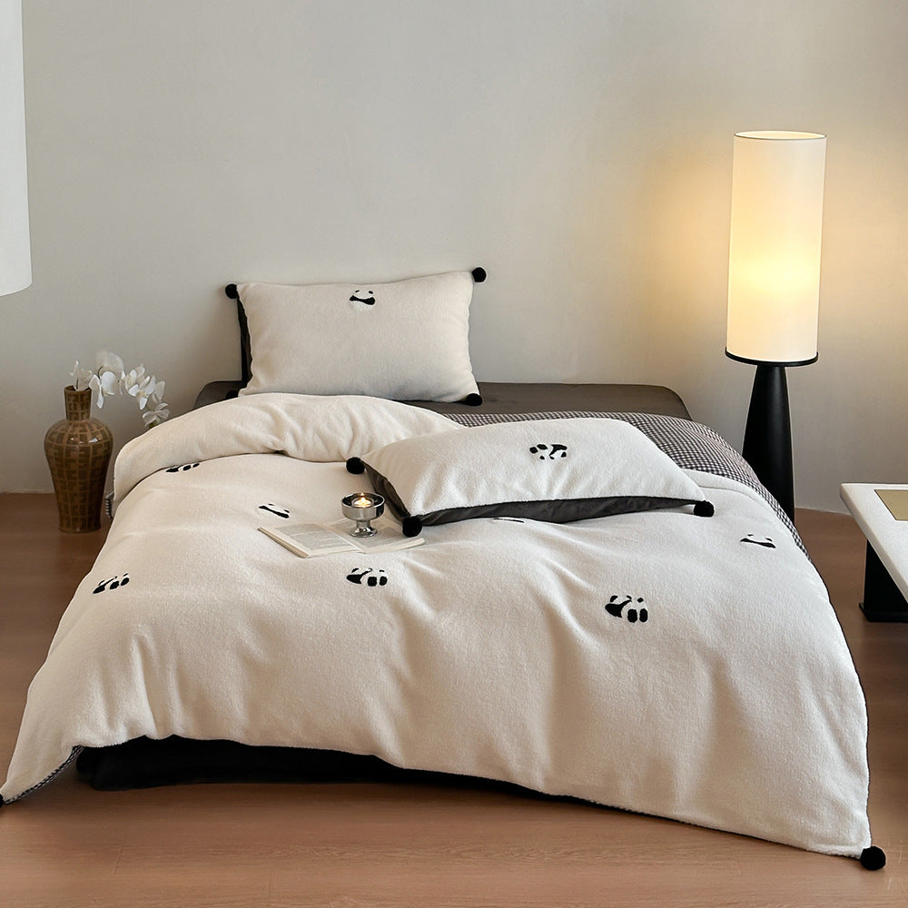 Reversible microfiber bedding set with plush surface, pom-pom corners, and paw embroidery