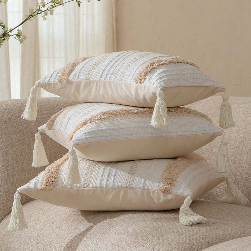 Square decorative cushion with boucle stripes, woven texture, and corner tassels