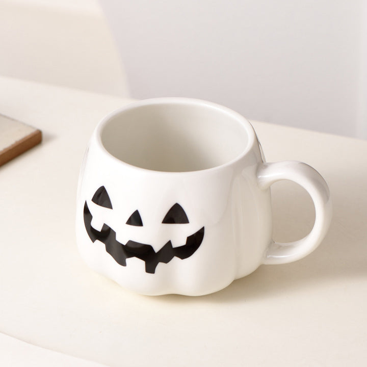 Ceramic mug in pumpkin shape with handle and carved face