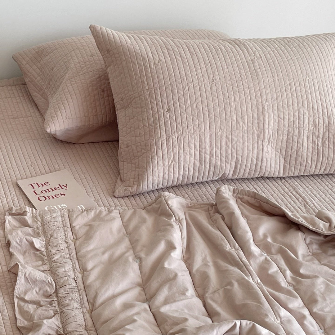 Quilted bedspread with delicate longitudinal stitching and matching pillowcases