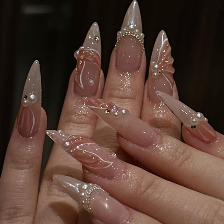 Artistic stiletto nails with pearl and flower embellishments Kalsten