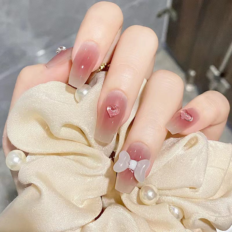 Artful acrylic nails with heart and bow design Kalsten