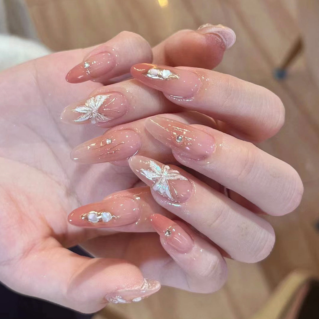 Artificial nail extensions with floral motifs and glitter accents Kalsten