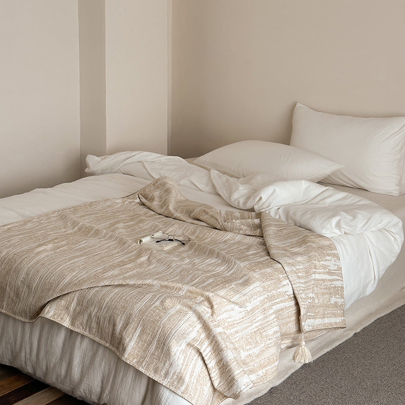 Woven blanket made of cotton blend with decorative tassels