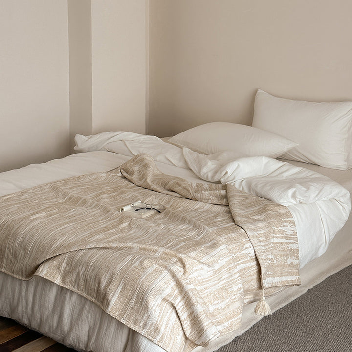 Woven blanket made of cotton blend with decorative tassels
