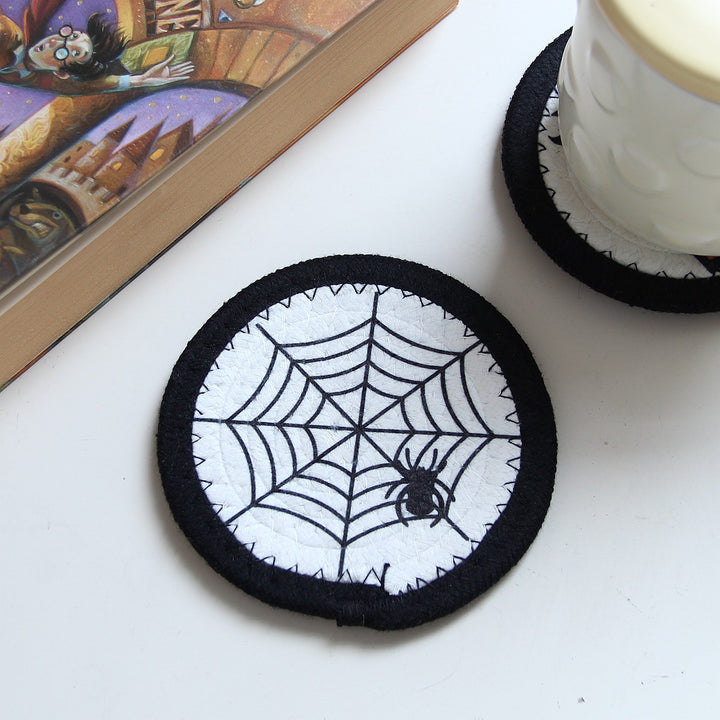 Round felt and cotton coasters with embroidered Halloween haunted house motif