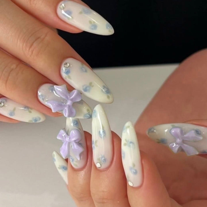 Artful stiletto nails with delicate flower patterns and glitter accents Kalsten
