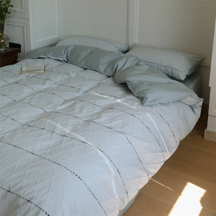 Reversible quilted bedding set made of cotton blend with textured leaf quilting and satin finish back