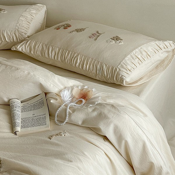 Cotton bedding set with delicate floral embroidery and ruffled edge