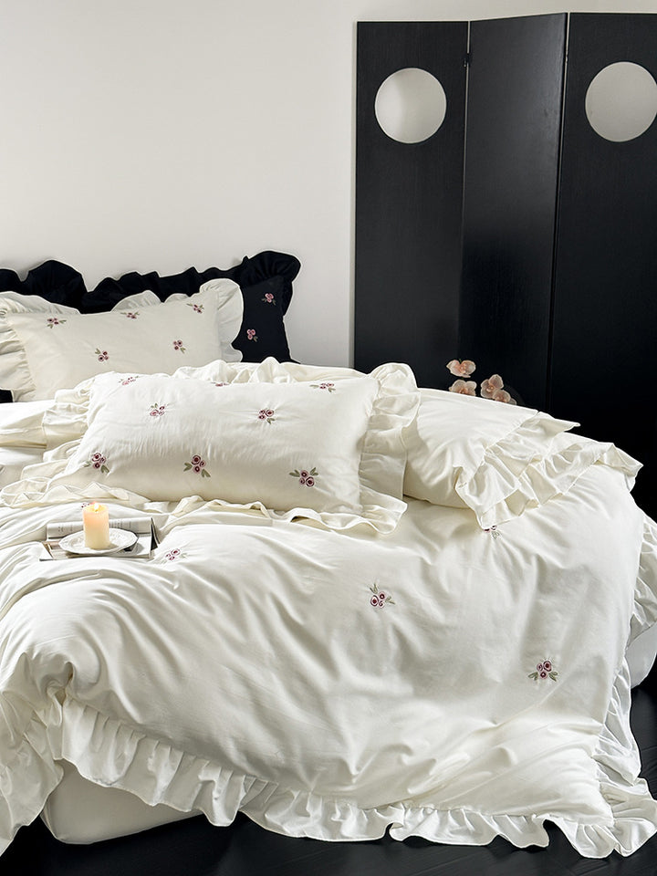Elegant bed linen set made of breathable cotton satin with delicate floral embroidery and ruffled hem