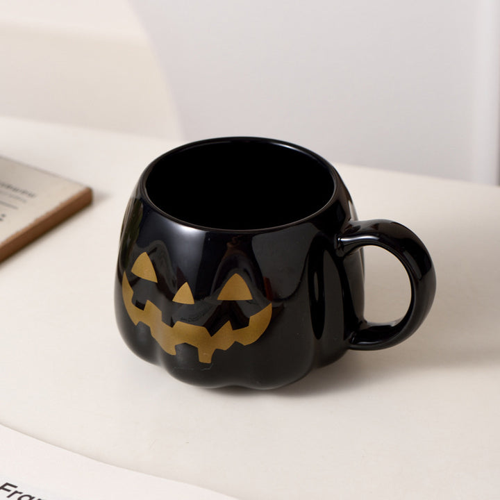 Ceramic mug in pumpkin shape with handle and carved face