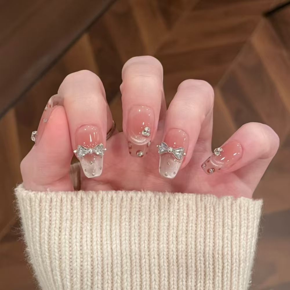 Art nails with delicate rhinestone and bow accents Kalsten