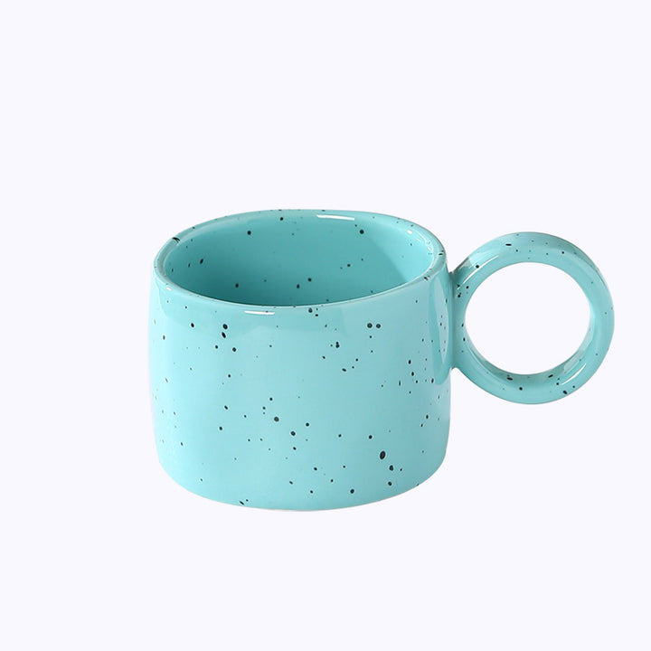Ceramic mug with heart-shaped handle and speckle design