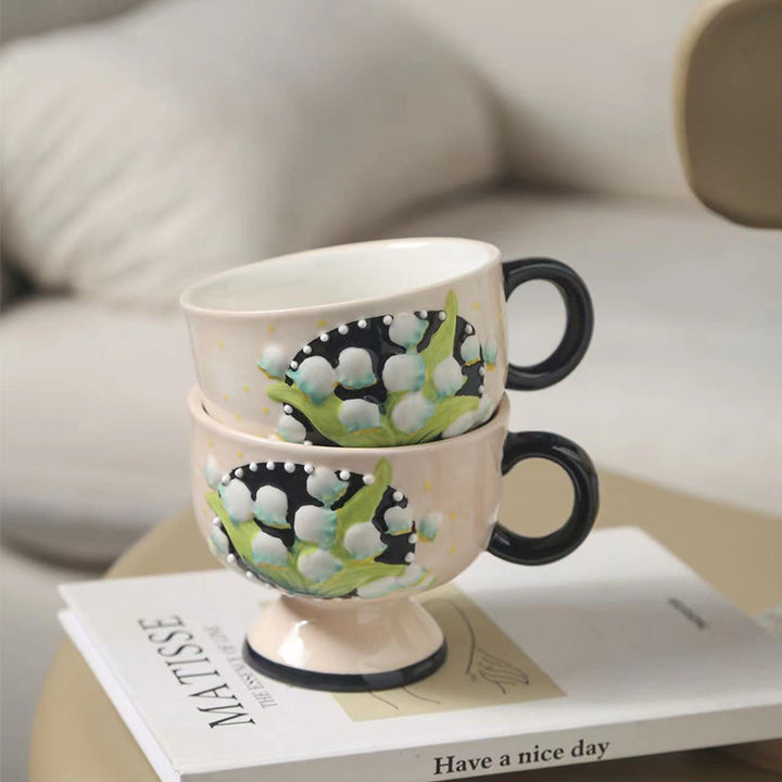 Ceramic foot cup with hand-painted lily of the valley relief and round handle