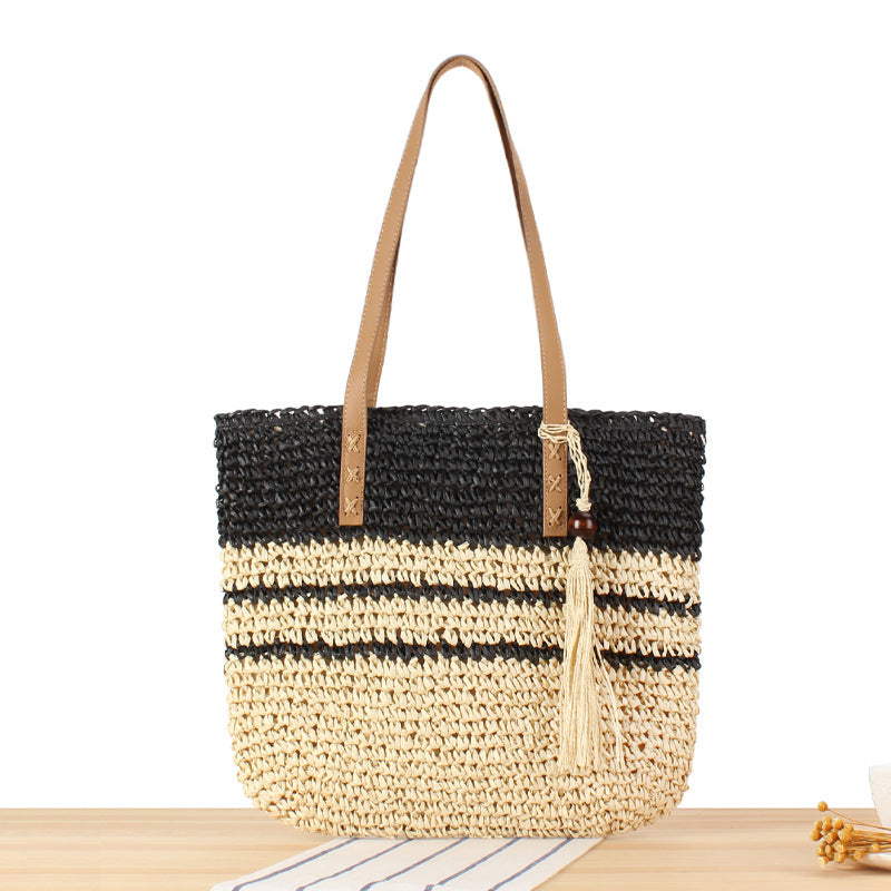 Handbag made of braided natural material with decorative tassel pendant Kalsten