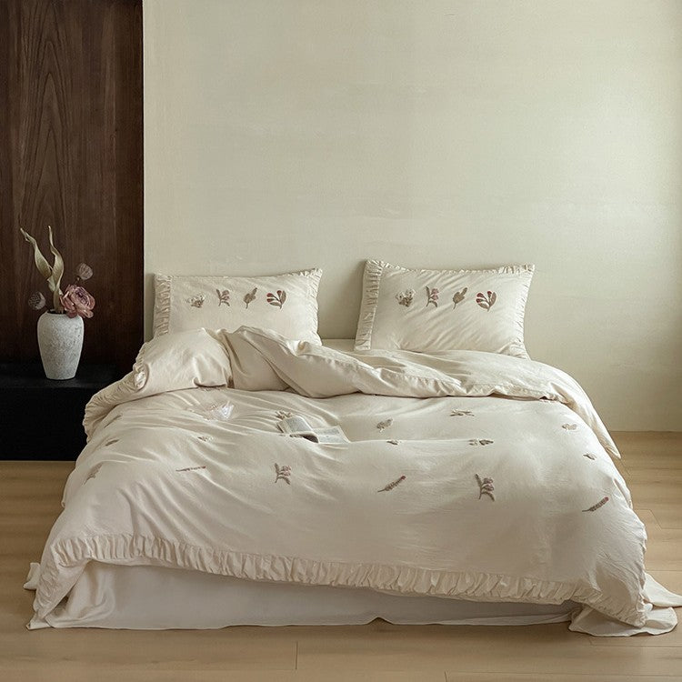Cotton bedding set with delicate floral embroidery and ruffled edge