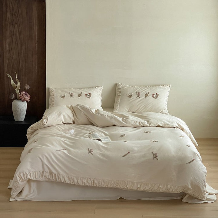 Cotton bedding set with delicate floral embroidery and ruffled edge