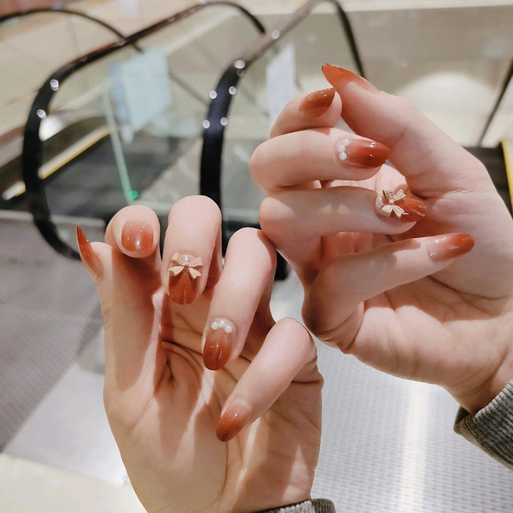 Artificial nails with elegant bow accents and pearl decorations Kalsten
