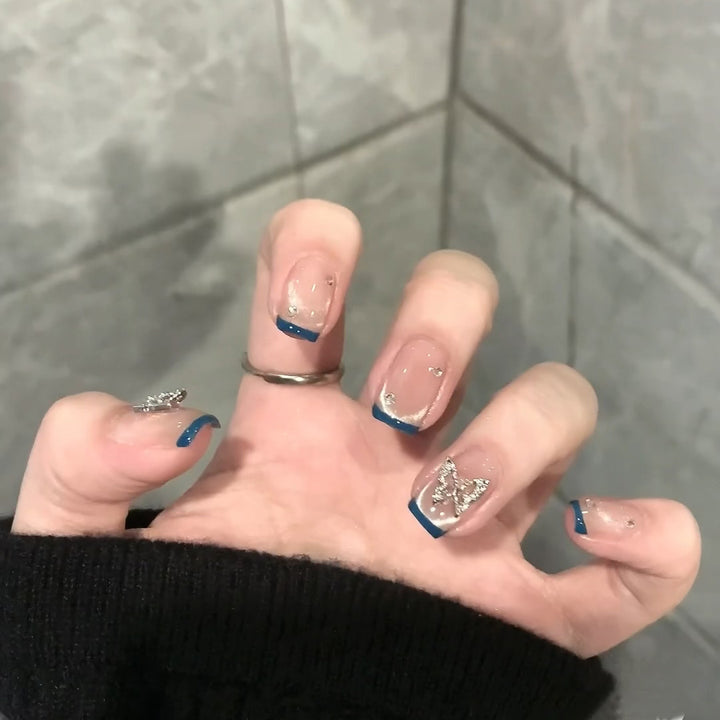 Artificial nails with trendy French tips and decorative glitter accents Kalsten