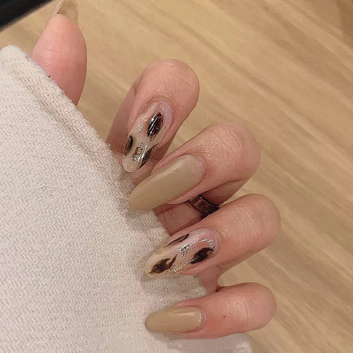 Artificial nail extensions with modern design and glitter accents Kalsten