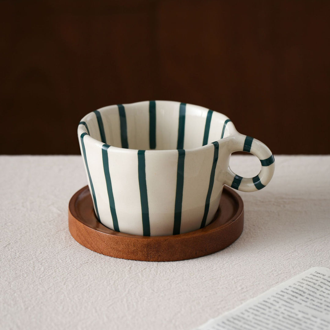 Ceramic espresso cup with round wooden coaster and handcrafted stripe pattern