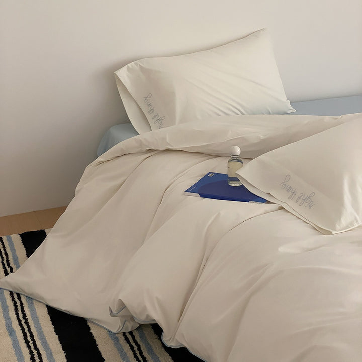 Cotton satin bed linen set with contrasting piping and subtle brand embroidery