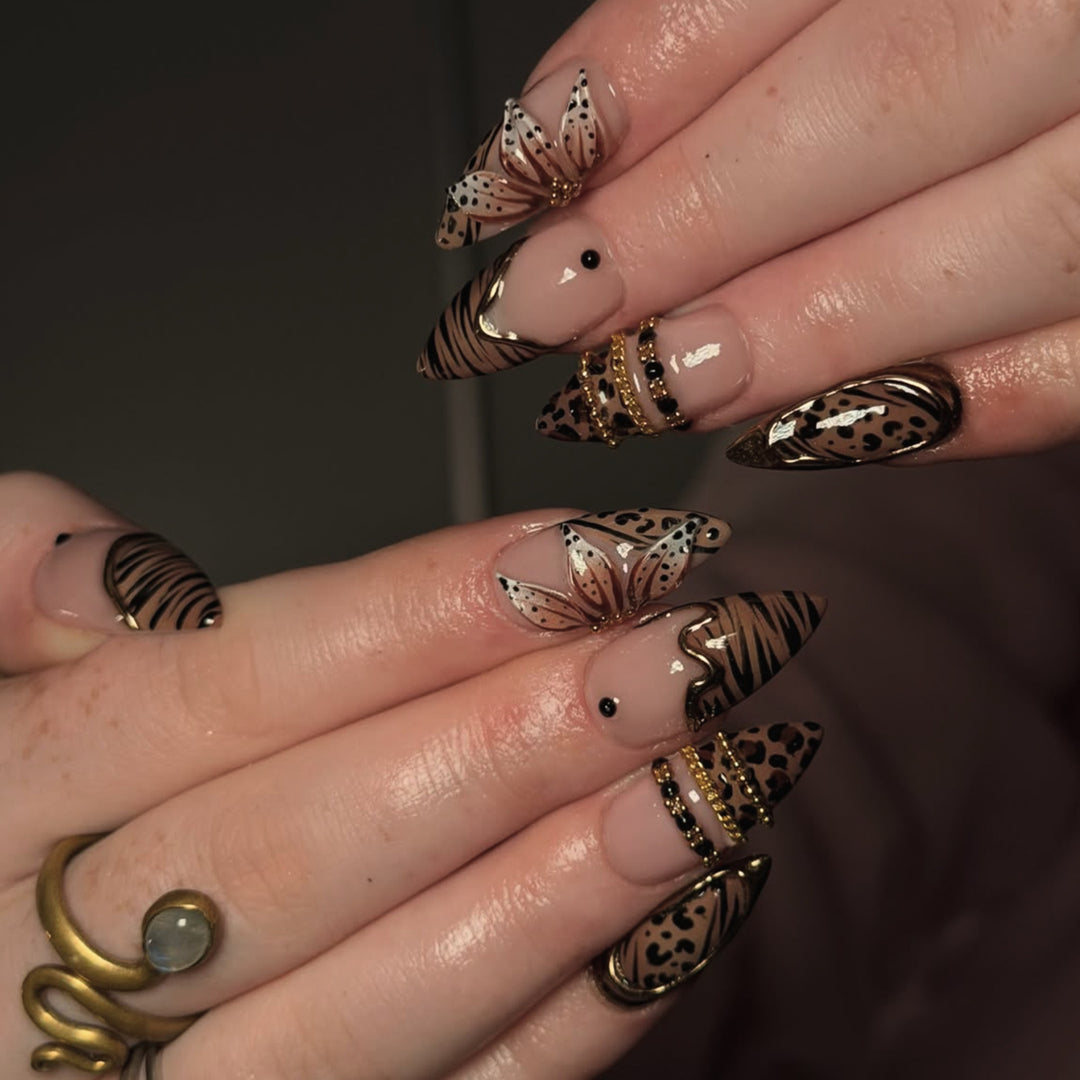 Artful stiletto nail with floral accents and gold embellishments Kalsten