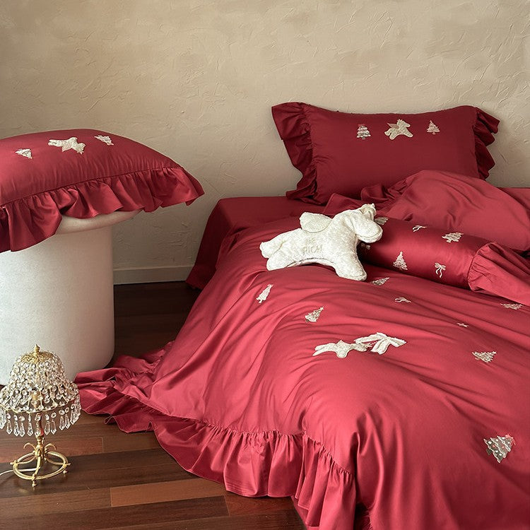 Festive satin bedding set with embroidered pine and mythical creature appliqués and ruffled cushion