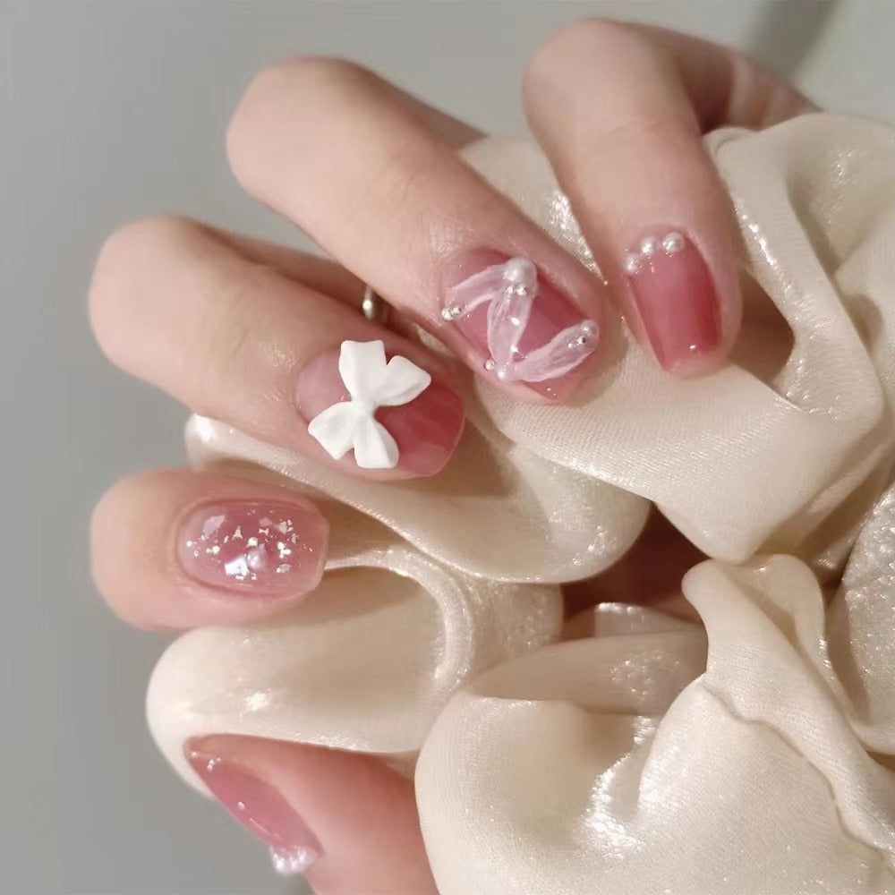 Glamorous nail art with pearl and bow accents Kalsten