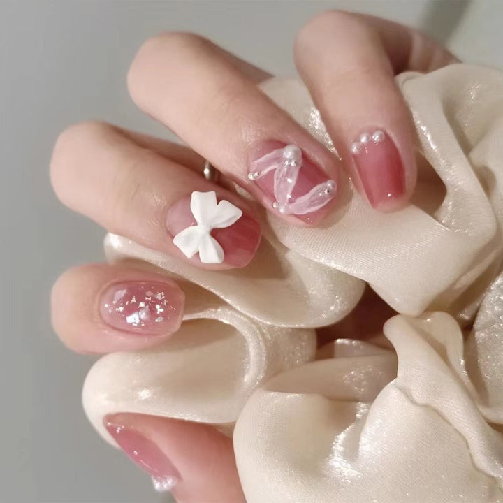 Glamorous nail art with pearl and bow accents Kalsten