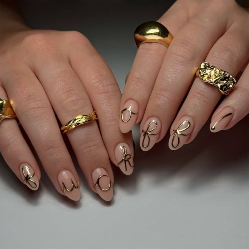 Creative nail art with golden accents and trendy lettering Kalsten