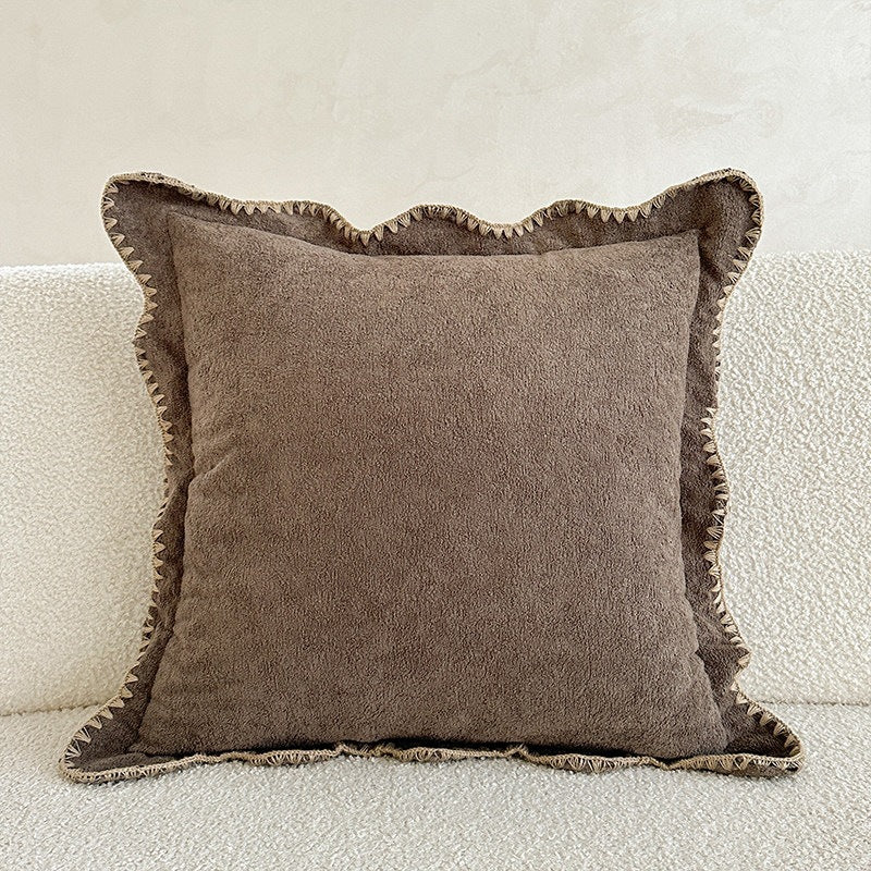 Decorative velvet cushion with wavy edge and decorative stitching