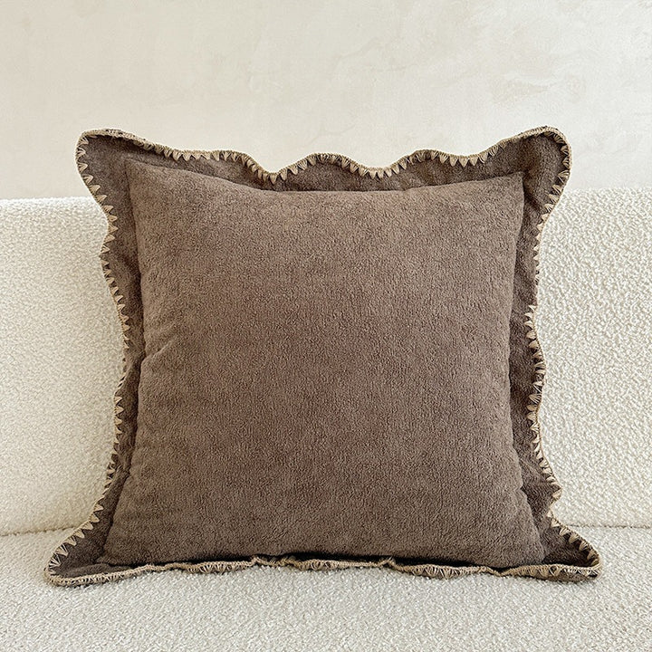 Decorative velvet cushion with wavy edge and decorative stitching