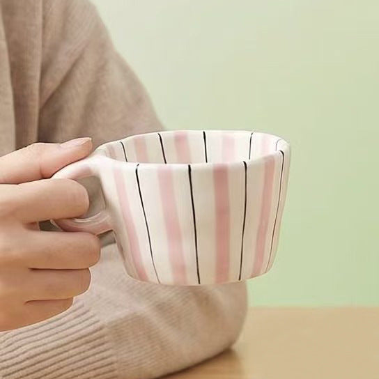 Ceramic coffee mug with ergonomic round handle and fine striped texture