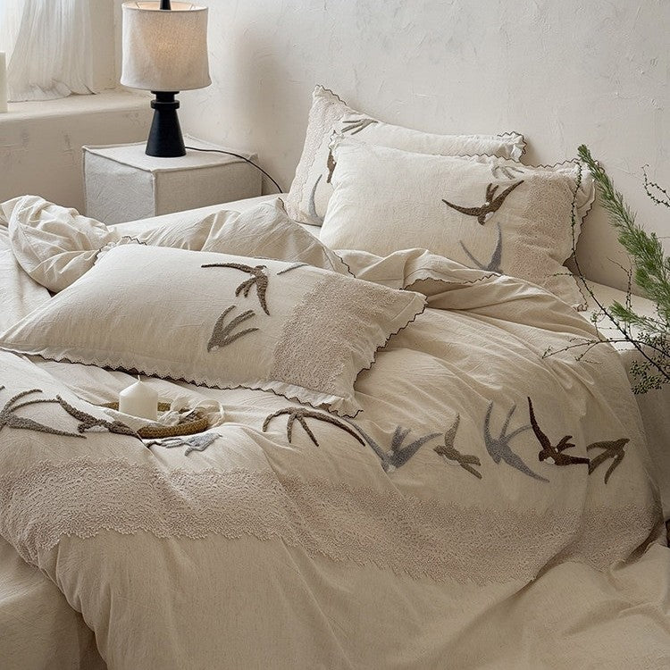 High-quality bedding set with embroidered swallows, lace trim and linen look