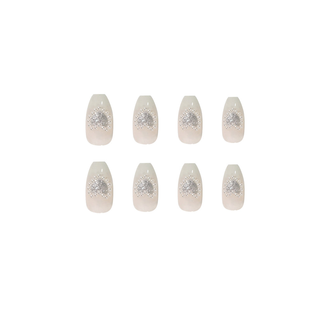Artificial nail art with heart and rhinestone decorations Kalsten