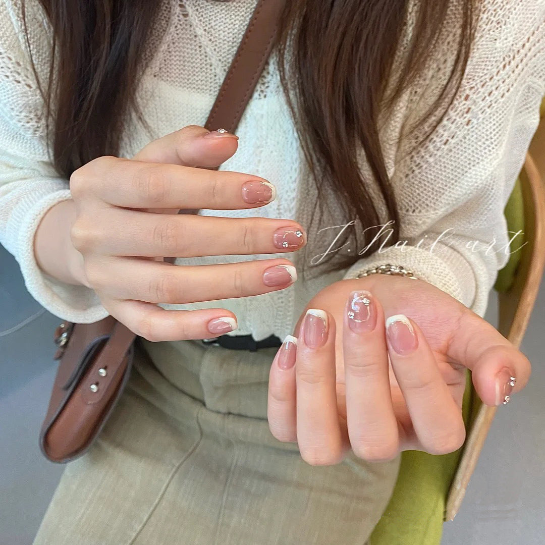Acrylic nail set with elegant French tips and glitter accents Kalsten