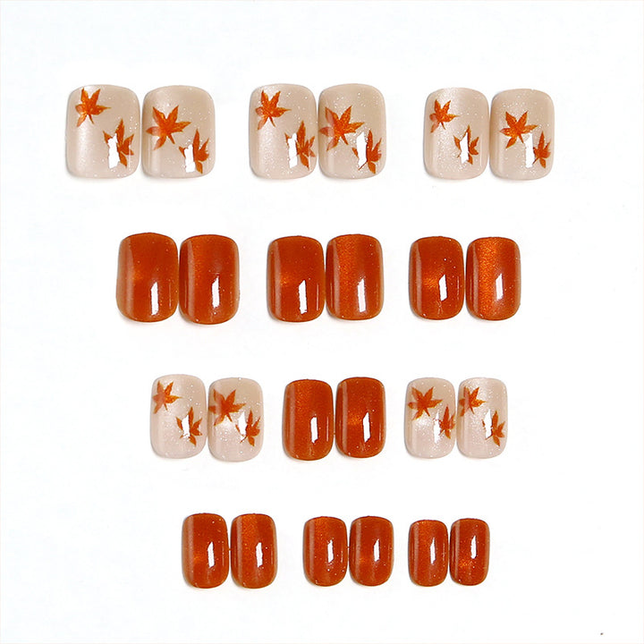 Artificial nails with glamorous ombre design and autumn leaf applications Kalsten