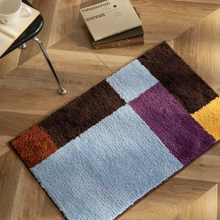 High-pile bath mat with geometric color block design and non-slip underside